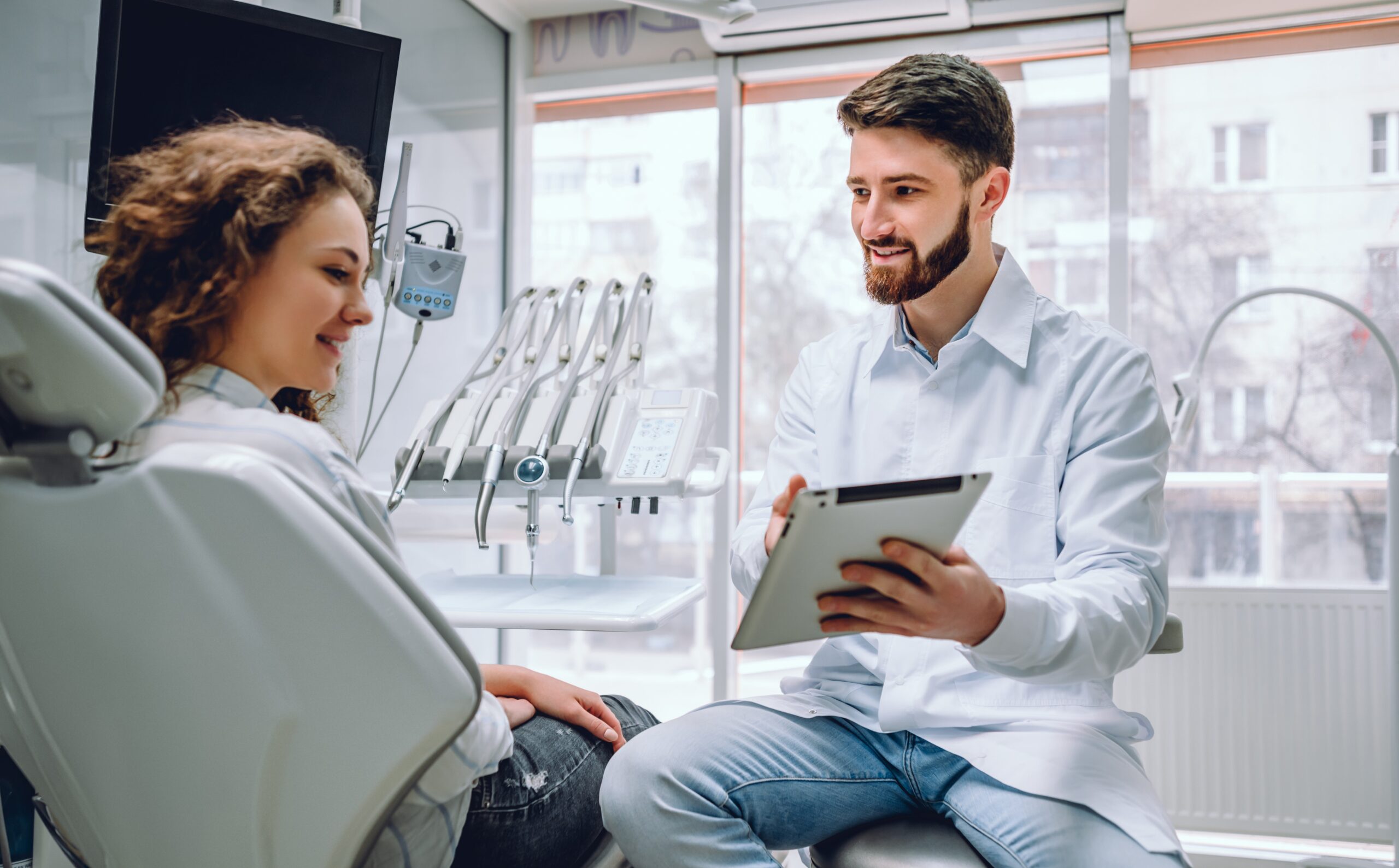 Dentist reviewing practice information on a tablet with a patient at a dental clinic